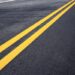 Traffic line of yellow on street with texture background.